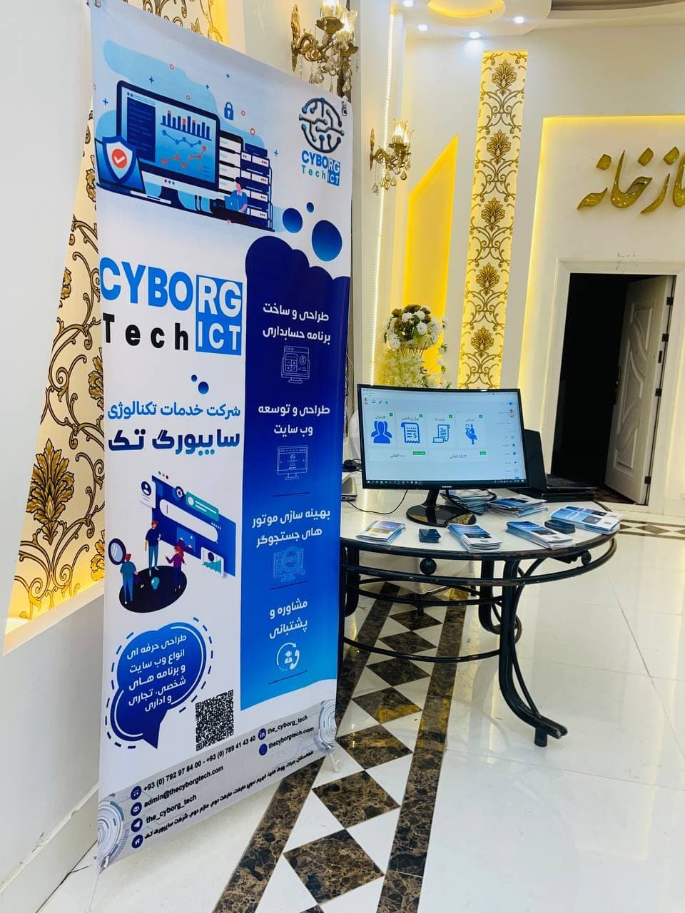 Cyborg Tech banner beside a monitor and printed product materials at the booth